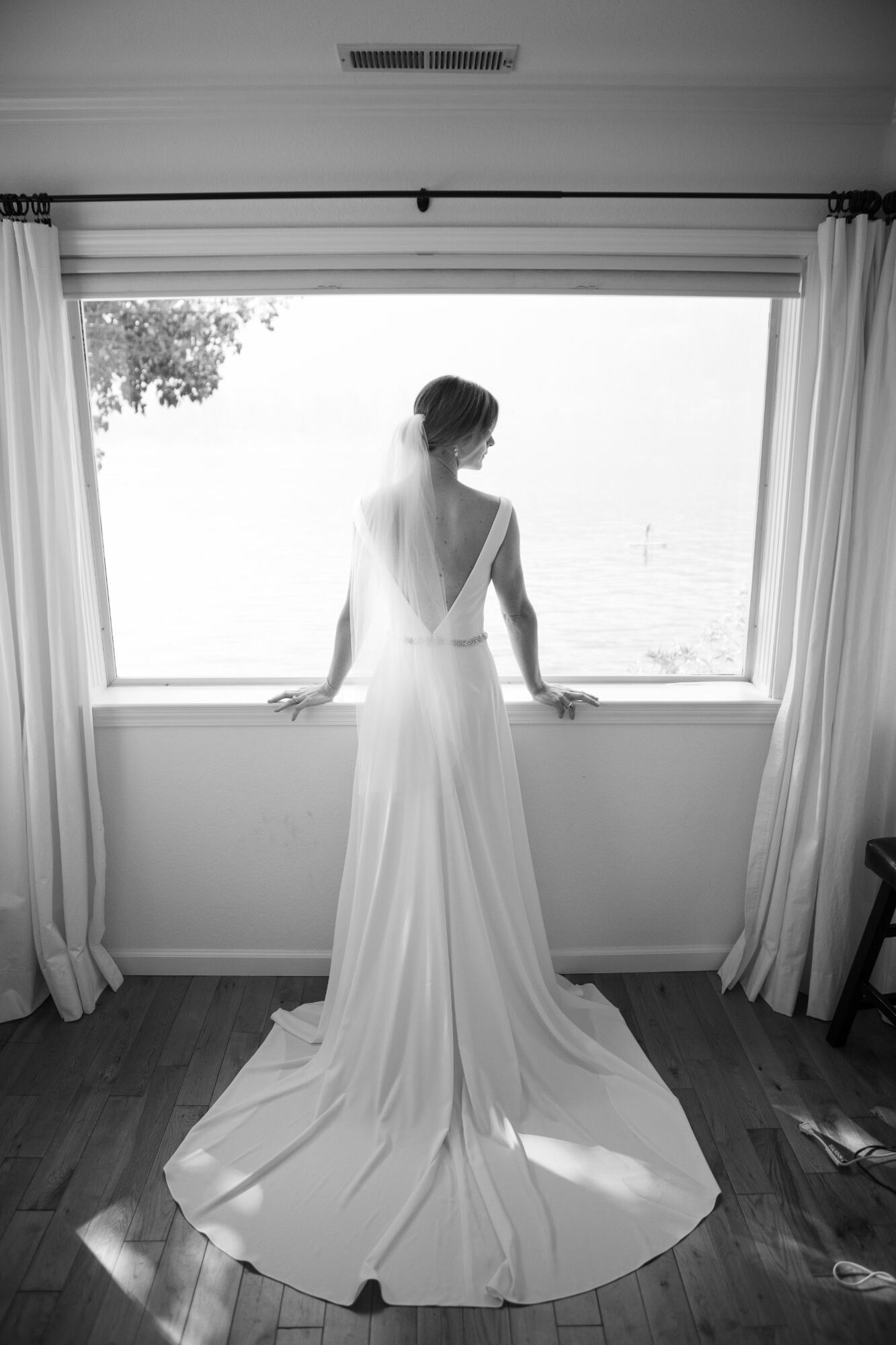 Bride standing quietly at a window before her ceremony