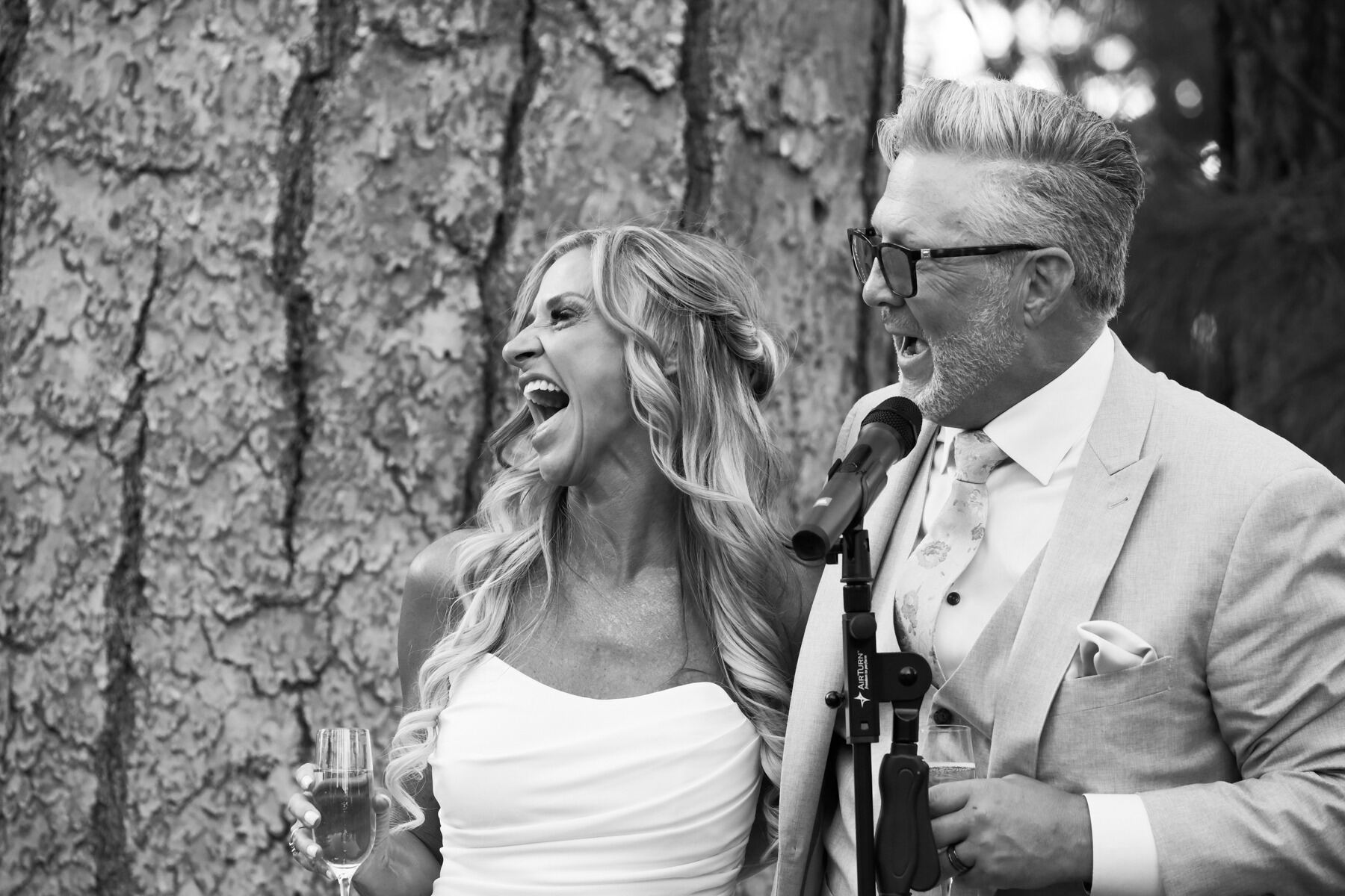 Bride and groom laughing together during their wedding toast